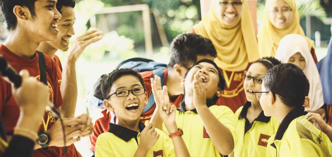 laughing children in between woman and man at daytime