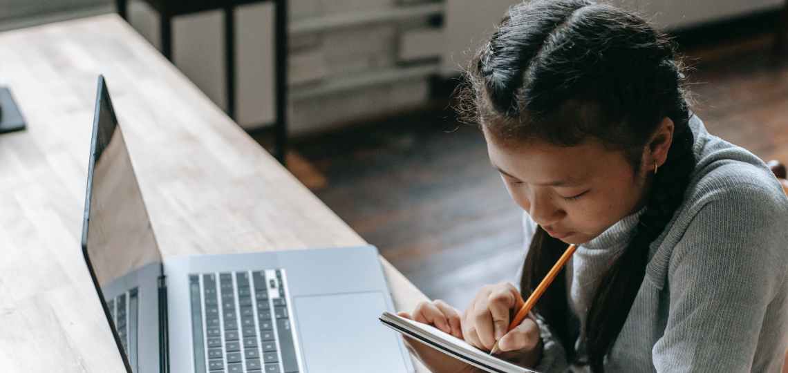 ethnic girl with laptop and notepad