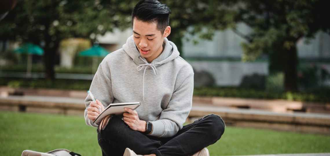 focused ethnic man with notebook and pen