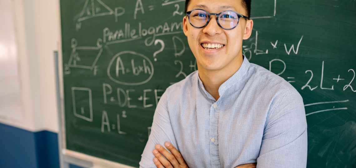 teacher standing beside a blackboard