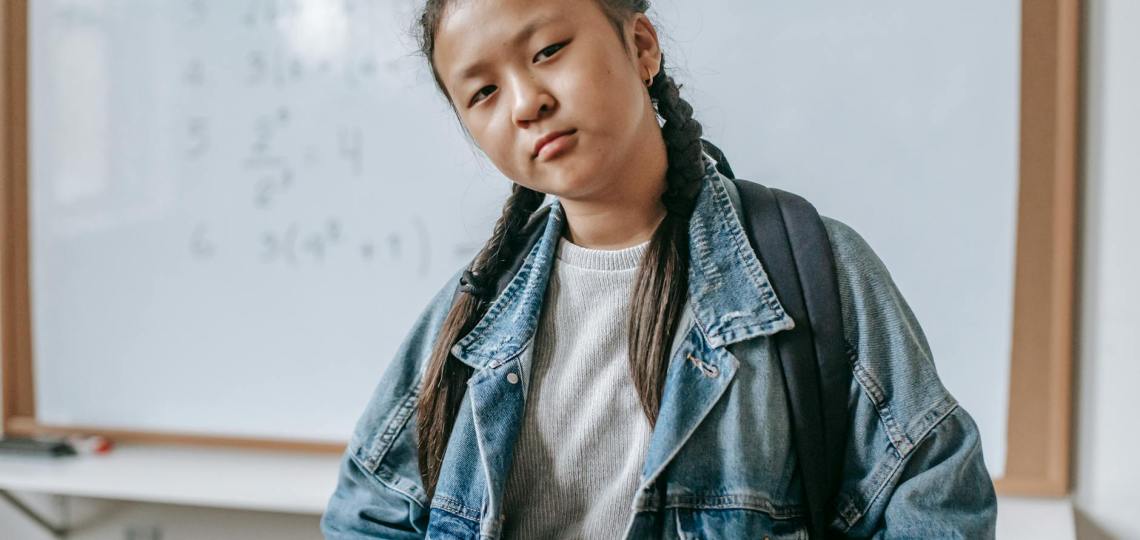 serious ethnic schoolgirl in classroom
