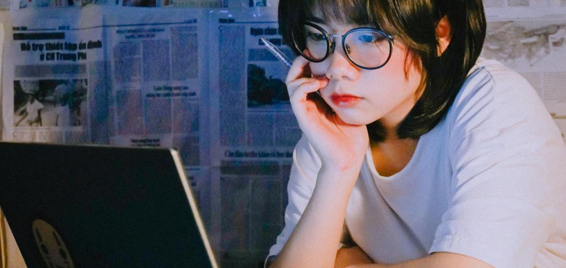 pretty woman in white crew neck t shirt looking at her laptop